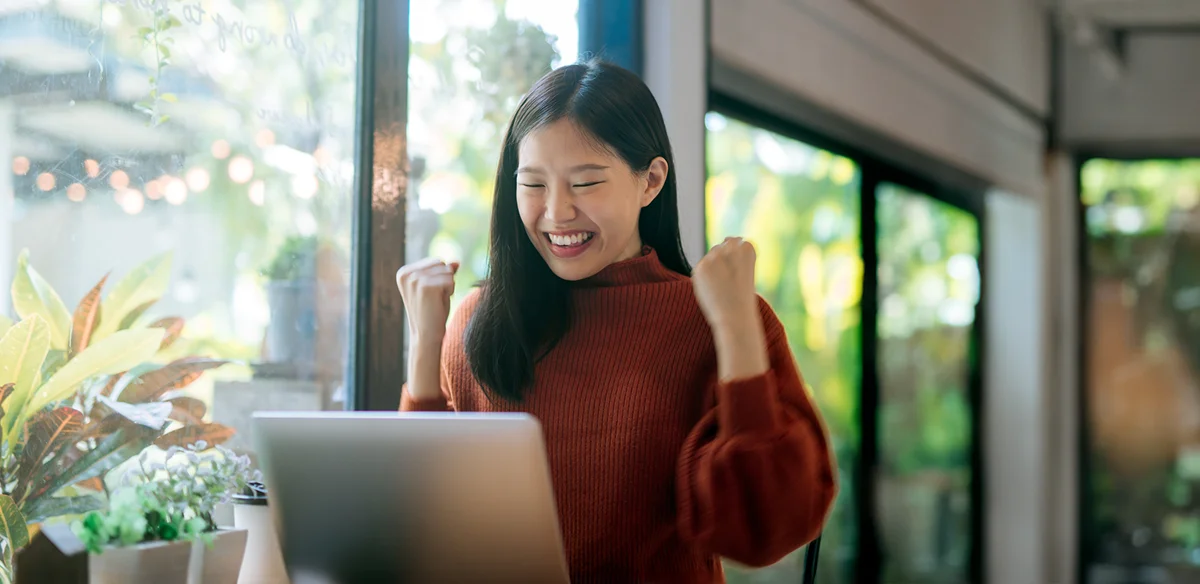 Student wearing a red sweater while working with her laptop
